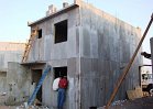 After concrete placement and curing, aluminum concrete forms are removed leaving foam insulation permanently bonded to the concrete